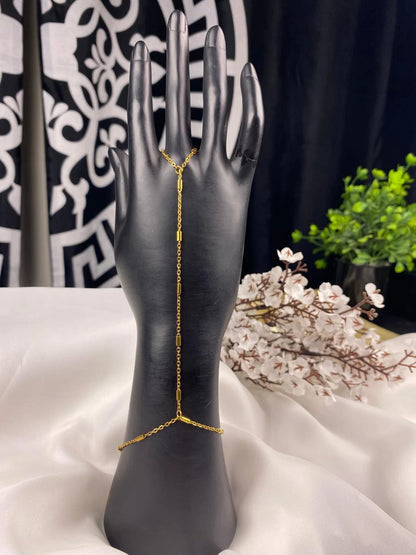 Gold chain bracelet on a black mannequin hand with a decorative background